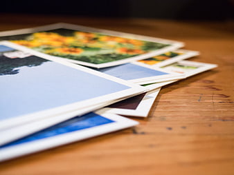 Stack of printed photographs on a wooden table