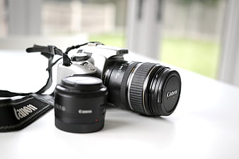 Silver Canon DSLR Camera with Lenses on White Table