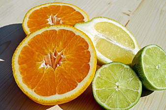 Fresh Cut Citrus Fruits Including Orange, Lemon, and Lime on Wooden Surface