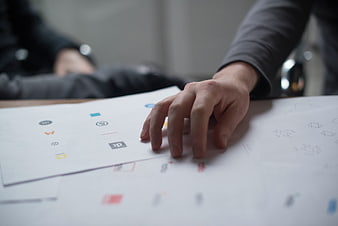 Hand selecting logo designs on paper