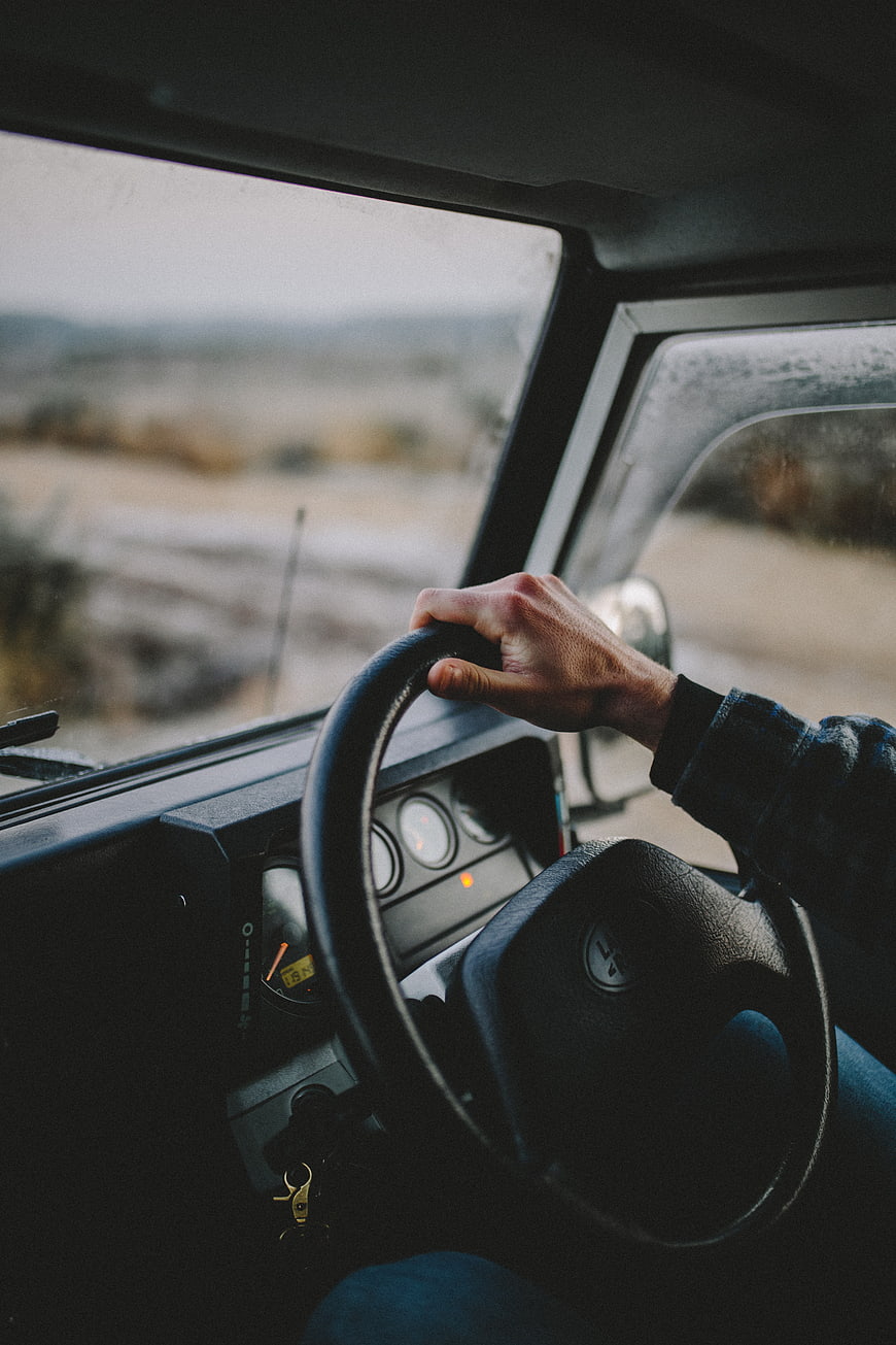 Man driving vintage off-road vehicle on rural road