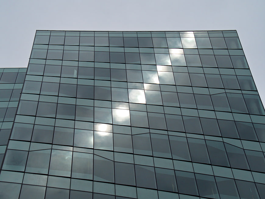 Modern Glass Office Building Facade with Sun Reflection