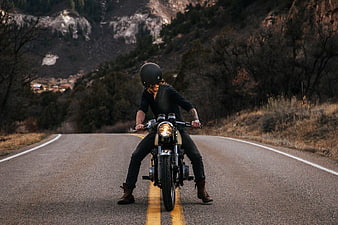 Man Riding Vintage Motorcycle on Mountain Road