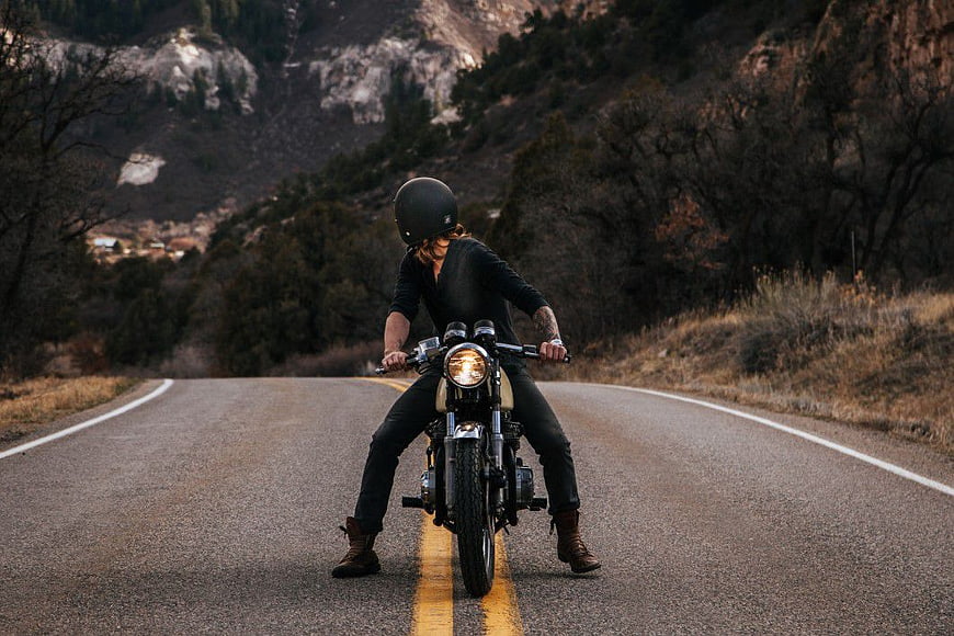 Man Riding Vintage Motorcycle on Mountain Road