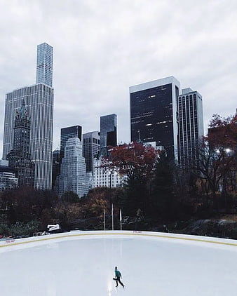 Lone Skater on Ice Rink with Chicago Skyline Background