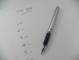 Silver pen on a handwritten to-do list on white paper