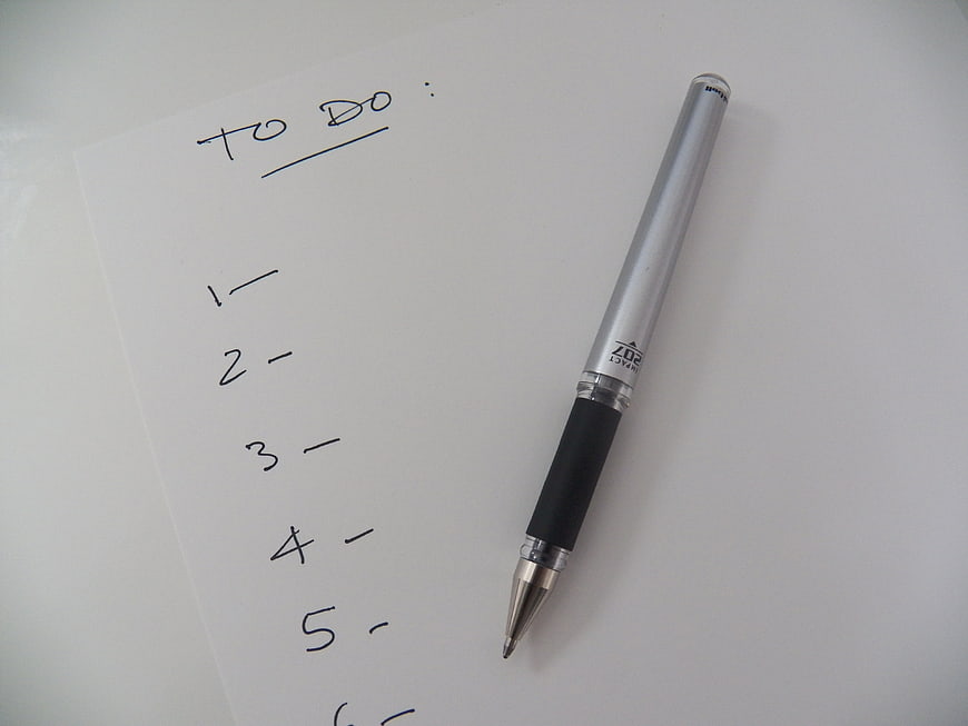 Silver pen on a handwritten to-do list on white paper
