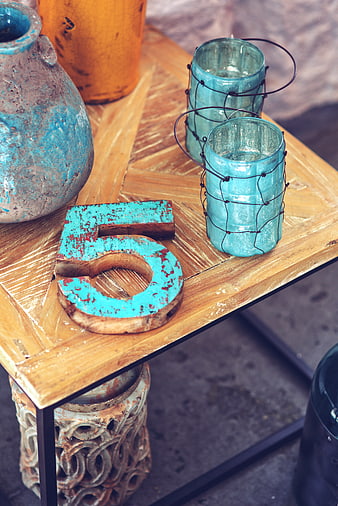 Rustic wooden number 5 and teal glass candle holders on table