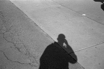 Black and white shadow of person on sidewalk