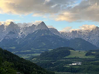 Majestic Alpine Mountain Range with Green Valley and Clouds