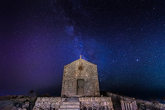 Stone chapel under Milky Way night sky