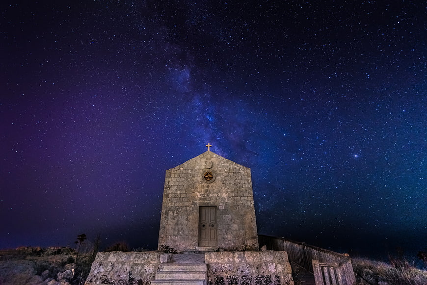 Stone chapel under Milky Way night sky