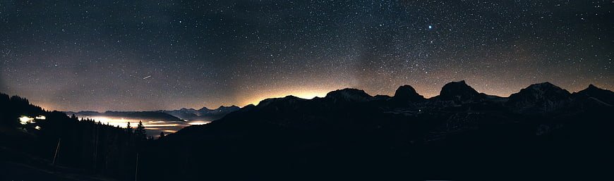 Panoramic Night Sky Over Mountain Range with Starry Sky and Lake