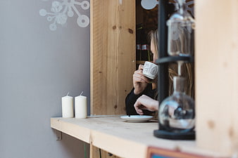 Woman drinking coffee in cozy cafe window seat