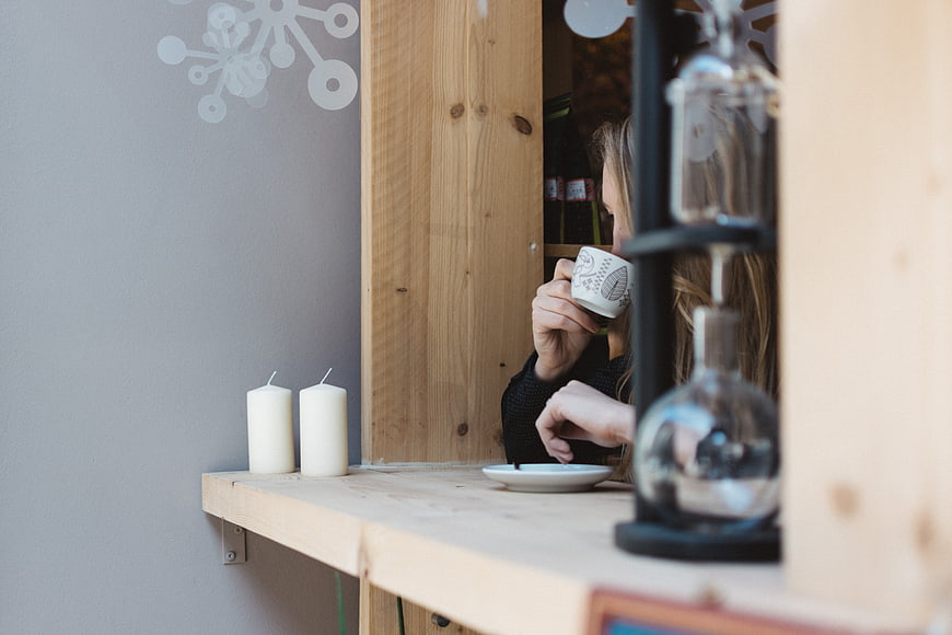Woman drinking coffee in cozy cafe window seat