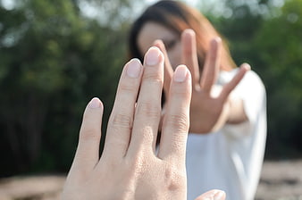 Woman with hands reaching out in a blurred outdoor setting