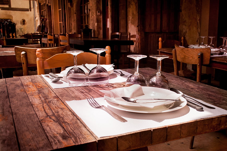 Rustic wooden table set with wine glasses and cutlery