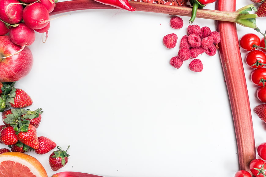 Red fruits and vegetables border on white background