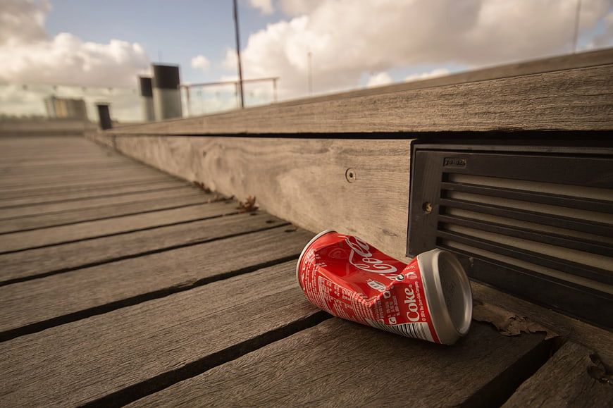 Crushed Coca-Cola Can on Wooden Deck
