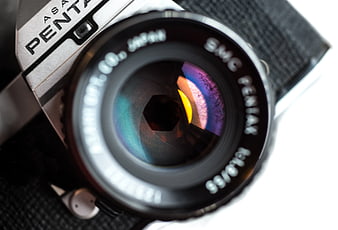 Close-up of vintage Pentax camera lens with colorful reflection