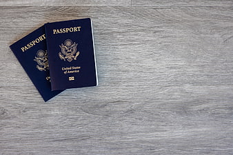 Two US Passports on Gray Wood Background with Copy Space
