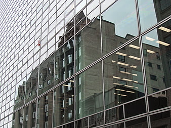 Modern glass building reflecting historic architecture in urban setting