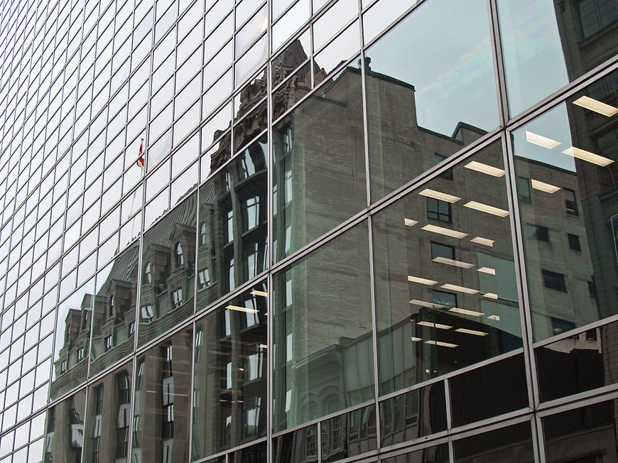Modern glass building reflecting historic architecture in urban setting