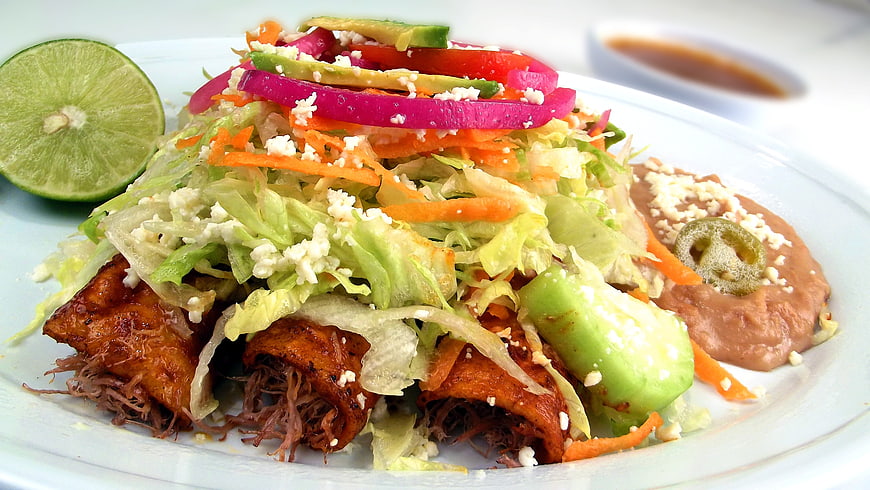 Mexican Enchiladas With Shredded Beef, Fresh Salad, And Refried Beans