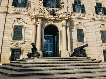 Historic Baroque Building Entrance with Cannons
