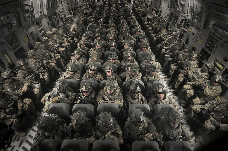 Soldiers seated inside military transport aircraft