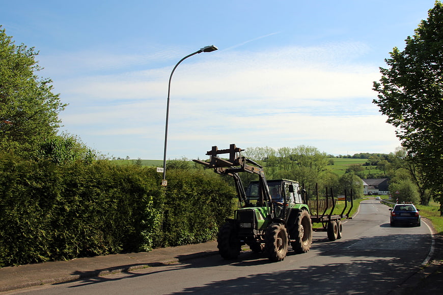 Green Tractor Transporting Timber on Rural Road