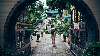 Woman Walking Through Archway In Traditional Chinese Garden