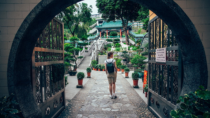 Woman Walking Through Archway In Traditional Chinese Garden