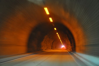 Motion blur view driving through a lit tunnel