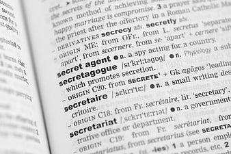 Close-up of dictionary page defining secret agent and secret