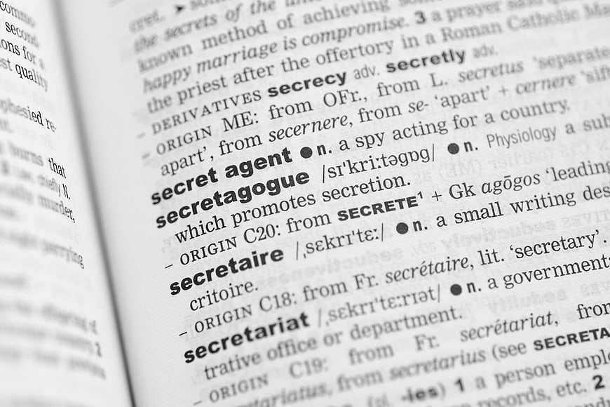 Close-up of dictionary page defining secret agent and secret
