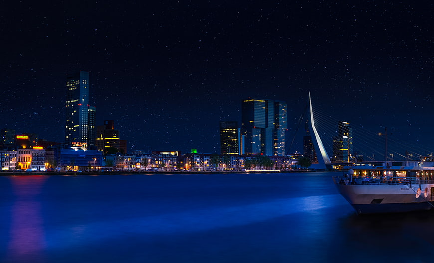 Rotterdam skyline at night with Erasmus Bridge and starry sky