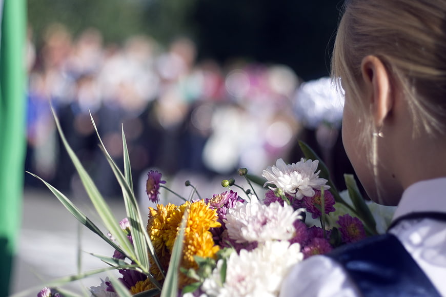 Girl holding flowers at school ceremony
