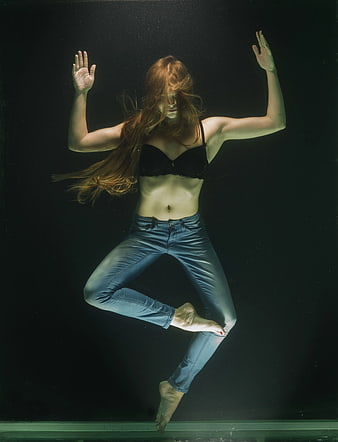 Woman Floating Underwater in Jeans and Black Bra