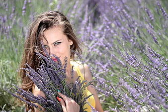 Woman holding lavender bouquet in purple flower field