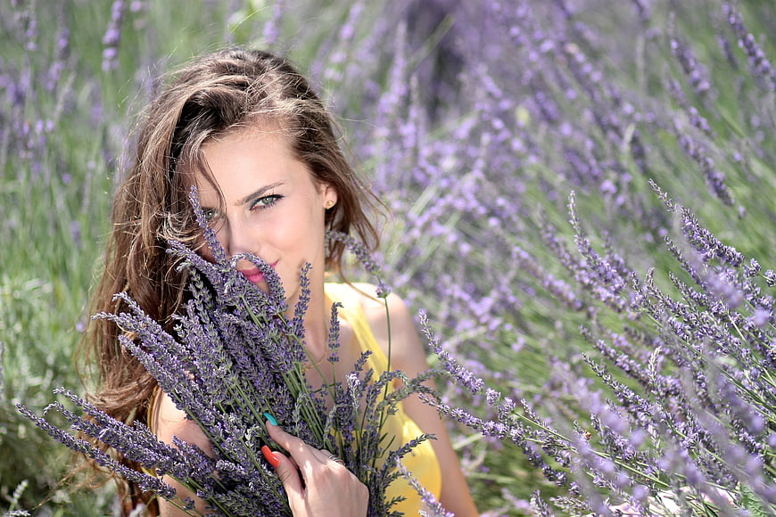 Woman holding lavender bouquet in purple flower field