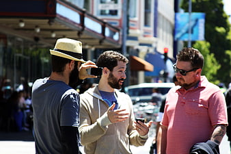 Three Men Talking on a Busy City Street