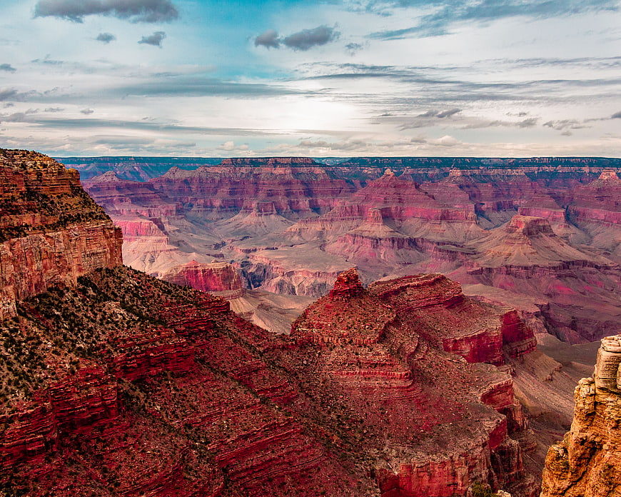 Grand Canyon Vista with Red Rock Formations and Cloudy Sky