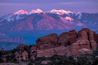 Red Rock Formations with Snow-Capped Mountains at Sunset