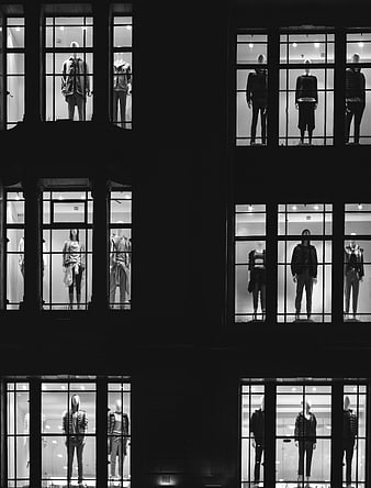 Black and white mannequins in multi-story shop windows