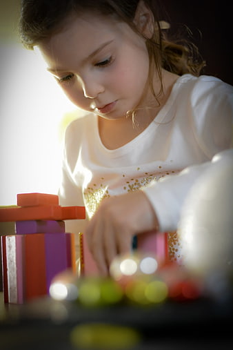 Young girl concentrating on colorful building blocks