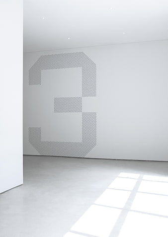 Minimalist white room with geometric grid pattern on wall