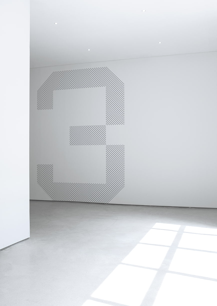 Minimalist white room with geometric grid pattern on wall