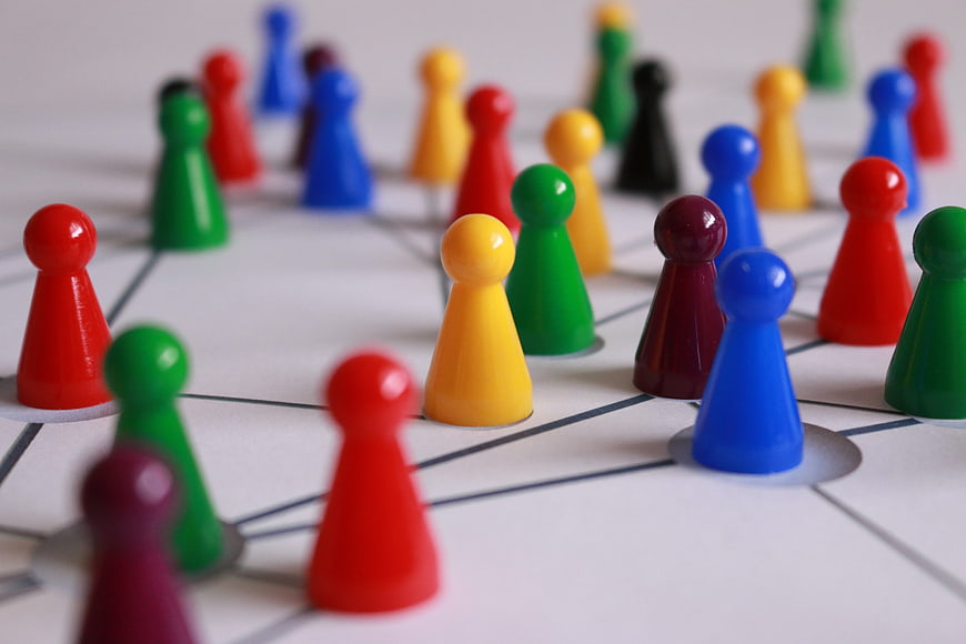 Colorful game pieces on network diagram representing teamwork