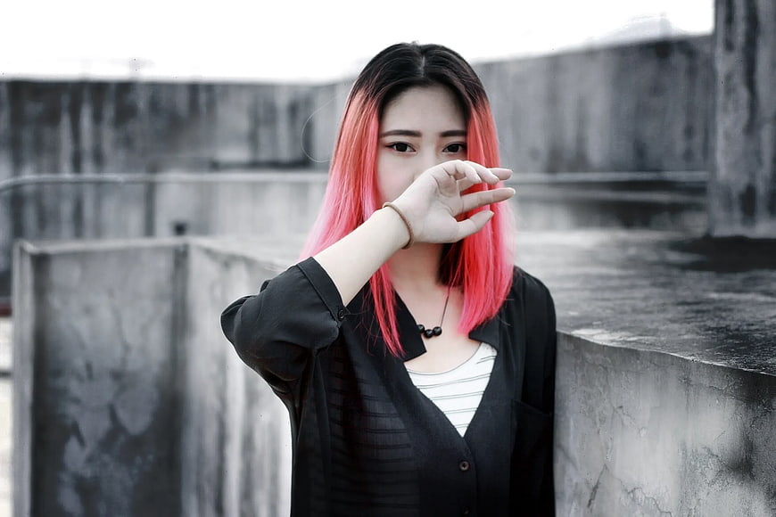 Woman with Pink Hair Making Hand Gesture on Concrete Rooftop